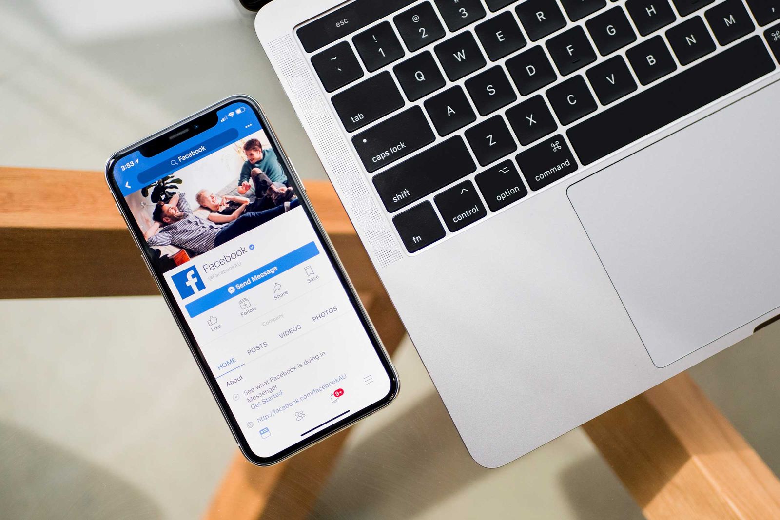 Foto de um celular com o aplicativo do Facebook aberto ao lado de um notebook. Técnicas para redução de custos dos anúncios no Meta Ads.