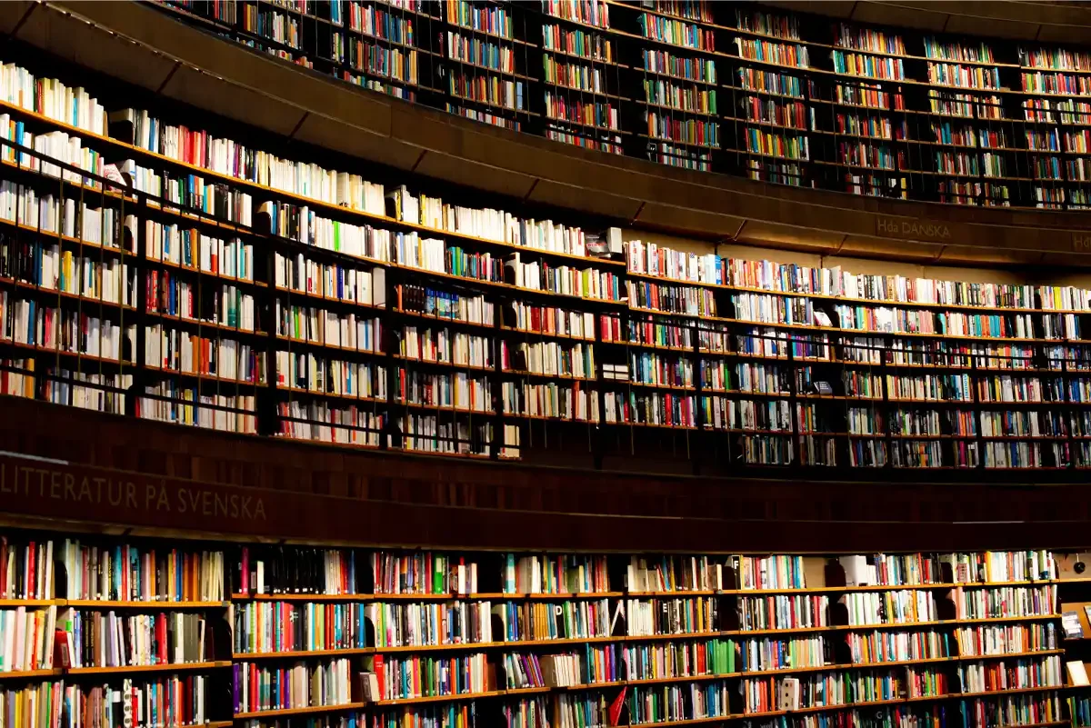 Simbolizando uma "biblioteca infinita", o Interior da biblioteca com uma parede de estantes repletas de livros diversos em Estocolmo.